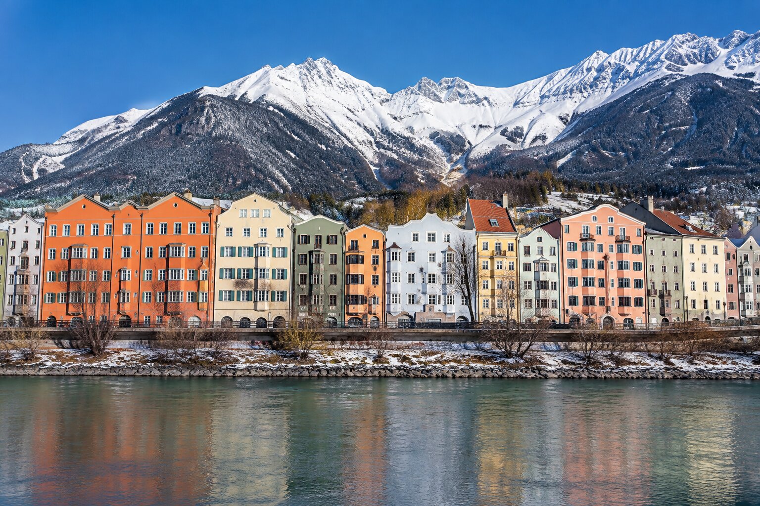 Las casas de colores junto al río Inn en Innsbruck, con los Alpes nevados