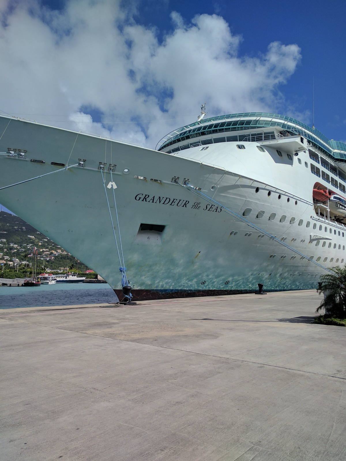 La proa del Grandeur of the Seas atracado en el muelle, con su nombre en el casco