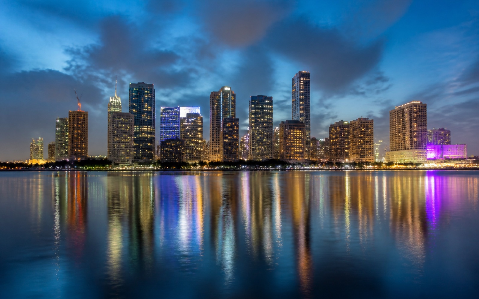 El centro de Miami de noche, con las luces reflejadas en el agua